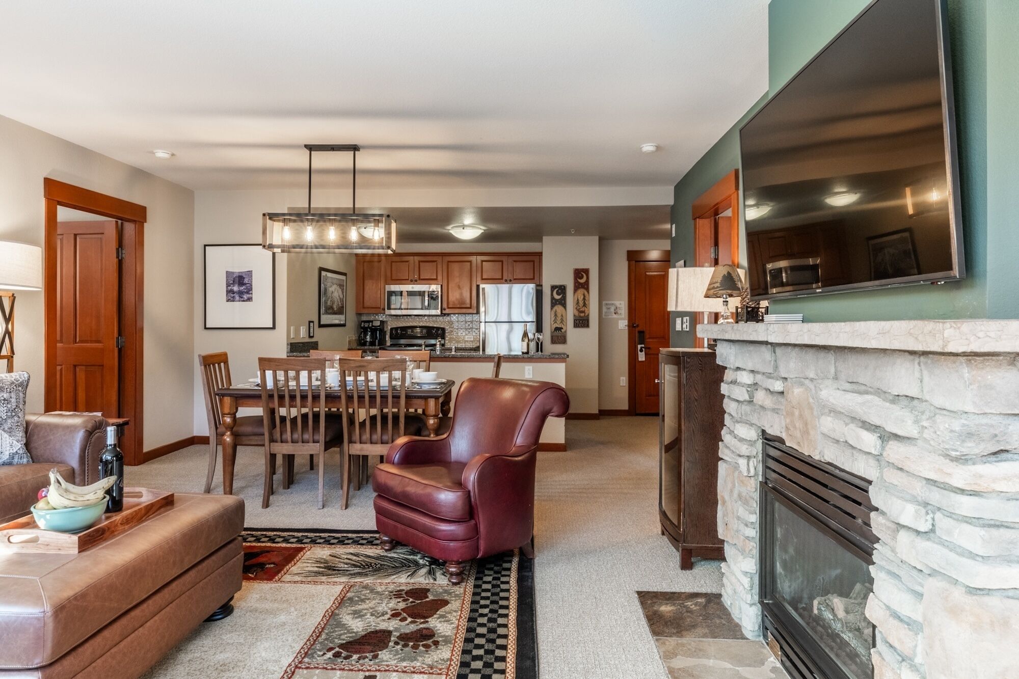 Een moderne woonkamer met een open haard, eethoek en keuken.