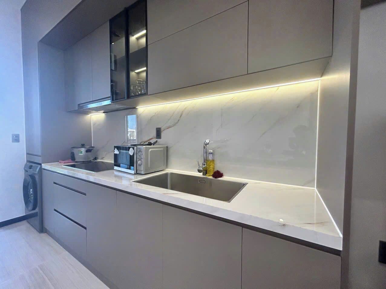 A modern kitchen with a built-in microwave, toaster, and sink.