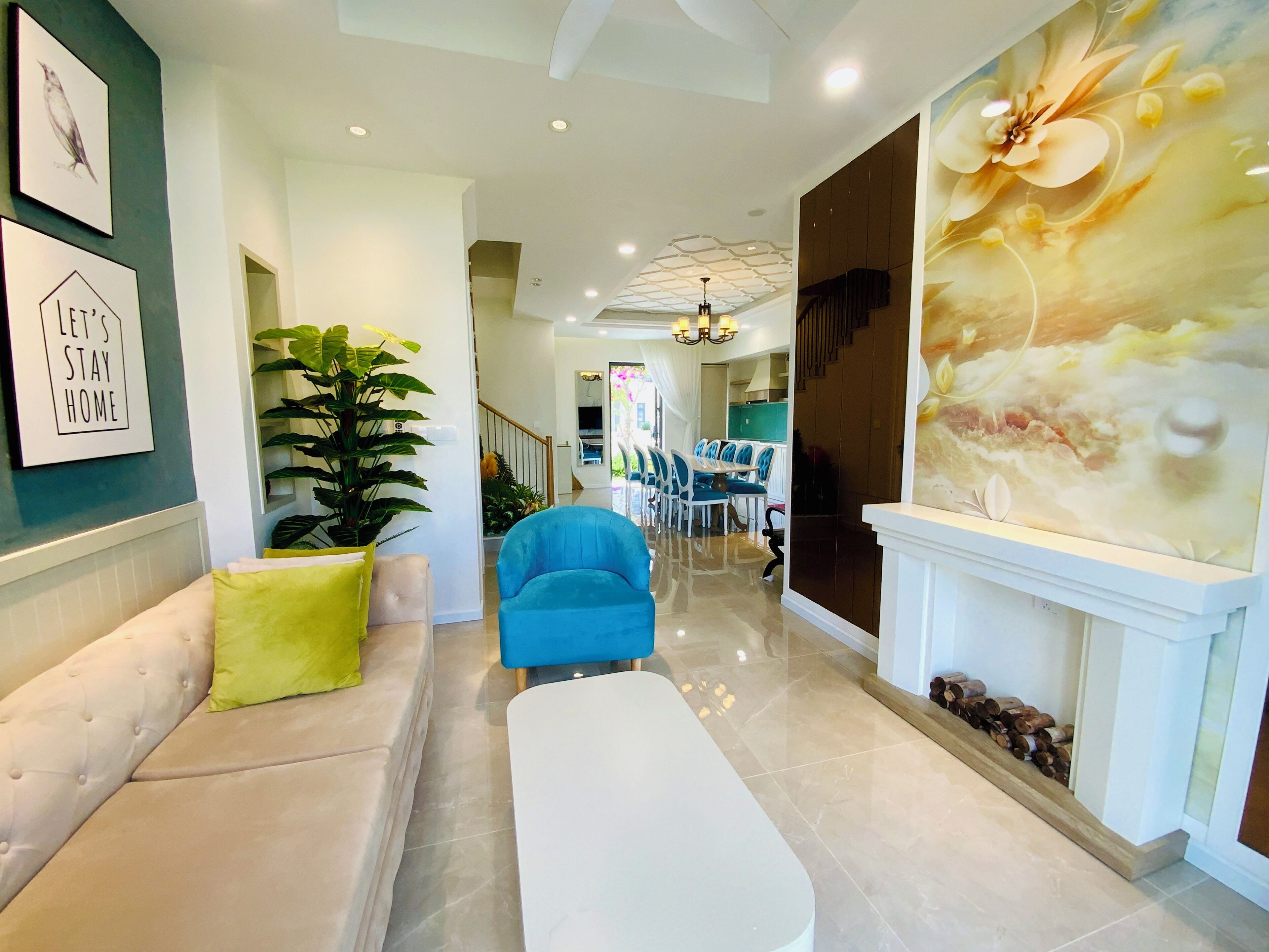 Un intérieur moderne comprenant un coin salon, un espace repas et un grand mur décoratif.