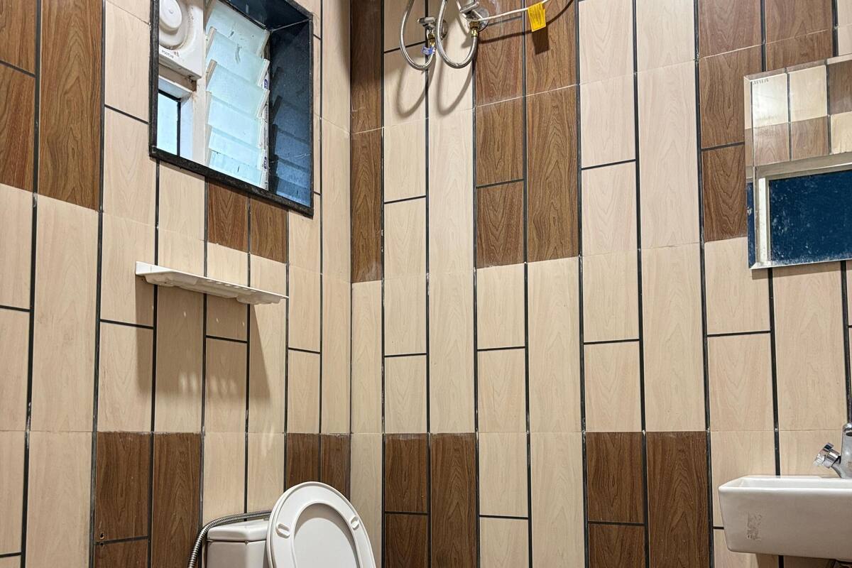 Une salle de bain équipée de toilettes, d’un lavabo et d’un chauffe-eau fixé au mur.