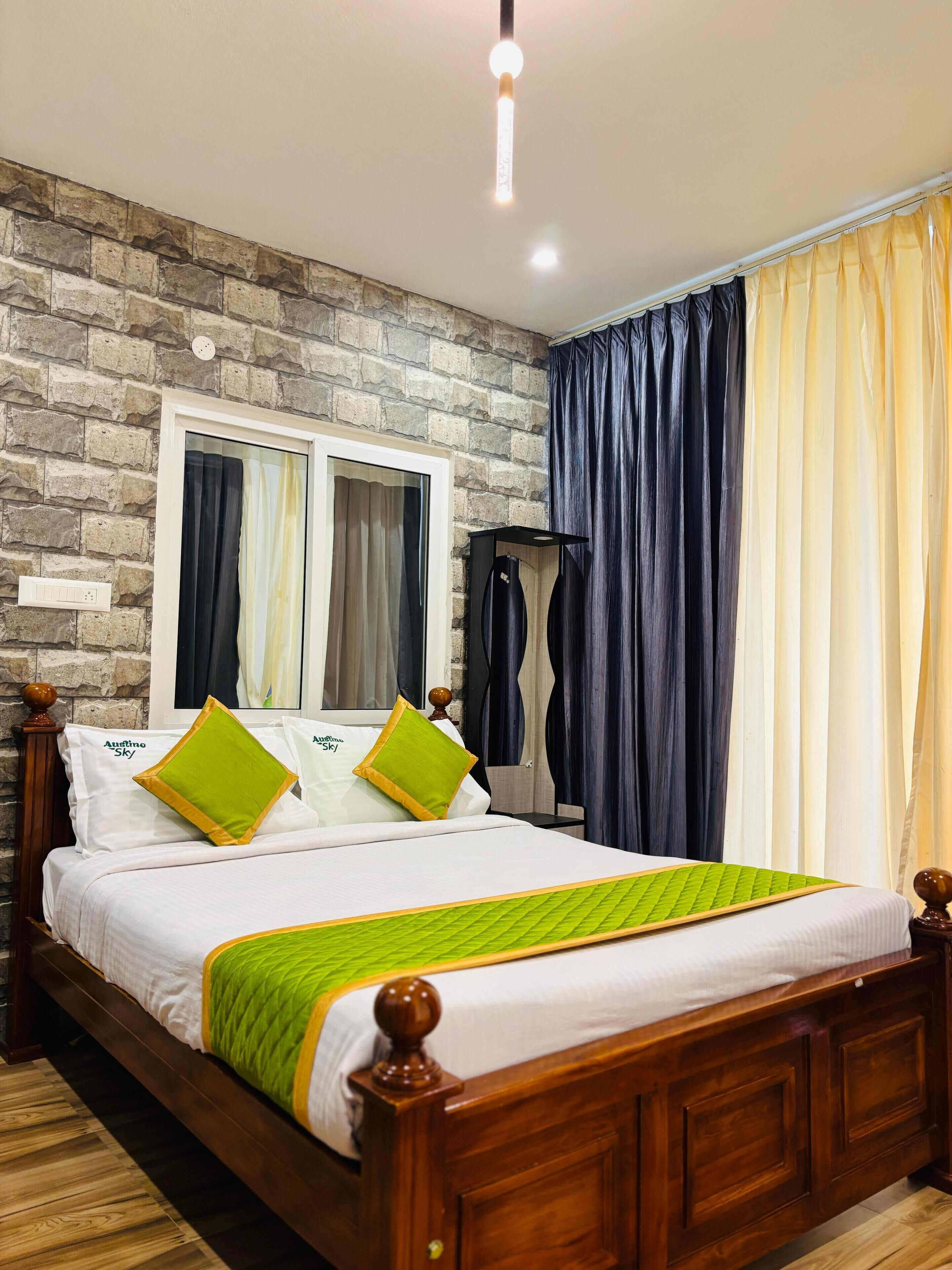 A neatly made bed with green and yellow pillows, a wooden headboard, and a stone wall behind it.