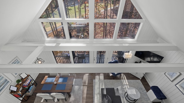 A multi-level interior with a dining area, seating, and a view of the outdoors through large windows. - 2-bedroom condo in Keowee Key: 3 pools, 2 restaurants, fitness center, golf (Salem)