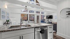 A modern kitchen with white cabinetry, a stainless steel dishwasher, and a granite countertop. - 2-bedroom condo in Keowee Key: 3 pools, 2 restaurants, fitness center, golf (Salem)