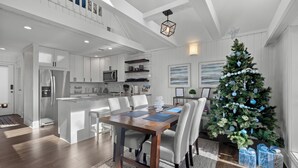 A modern kitchen with white cabinetry, a central island, and a dining area with a wooden table and chairs. - 2-bedroom condo in Keowee Key: 3 pools, 2 restaurants, fitness center, golf (Salem)