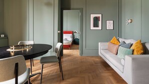 A room with a dining table, chairs, a sofa, and a bed. - Brera Apartments in Gae Aulenti (Milan)