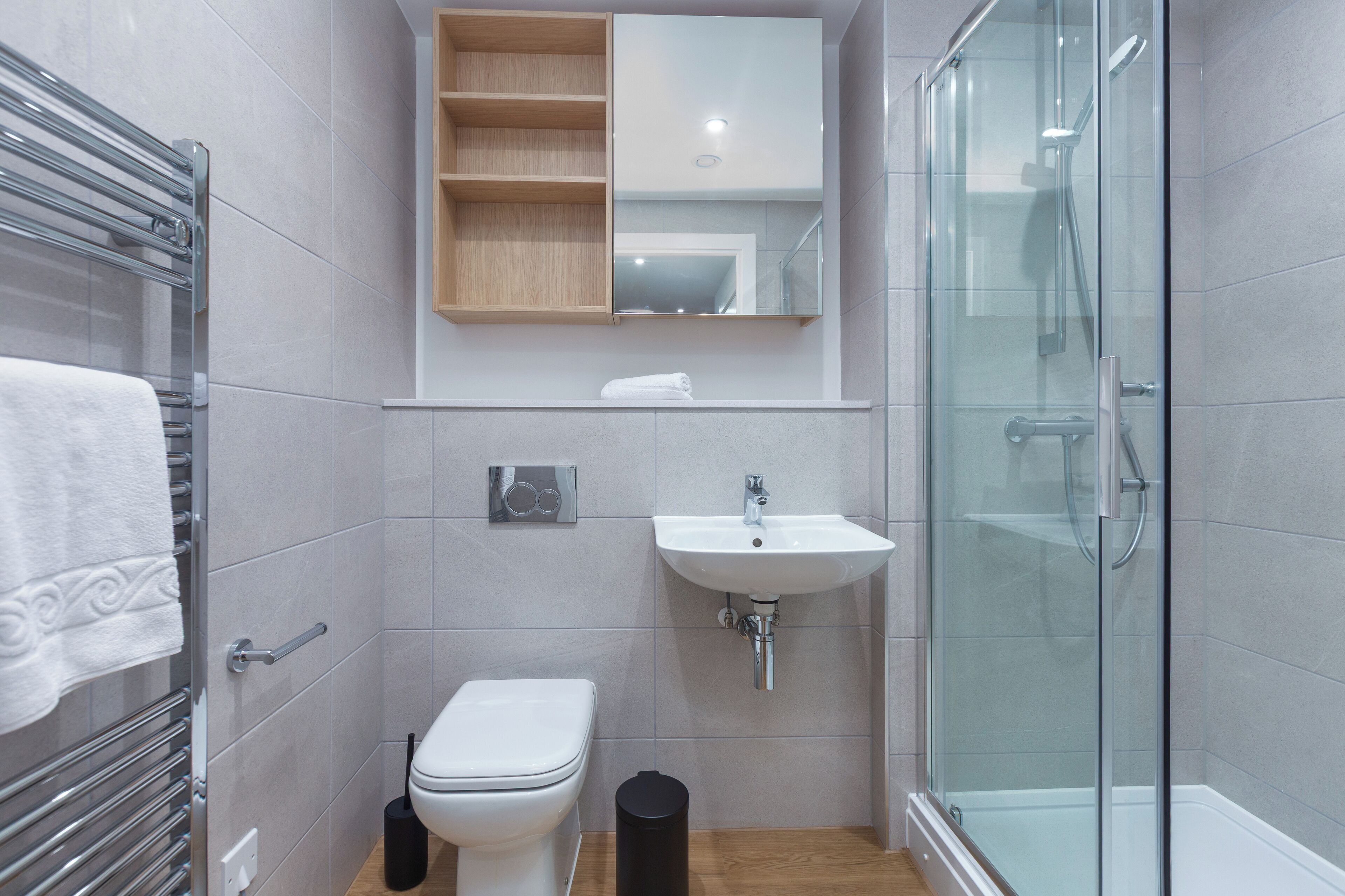 Une salle de bain moderne avec une douche à parois de verre, un lavabo blanc et des toilettes.