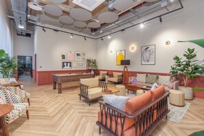 A spacious lounge area with multiple seating options, including sofas and chairs, arranged around a central coffee table. - Olive & Stone - Studio Apartment, Sleeps 2 (Bristol)