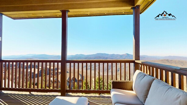 A wooden deck with a view of mountains, a wicker chair, and a sofa. - Reserve 32B • Family-Friendly Mountain Stay (Sugar Mountain)