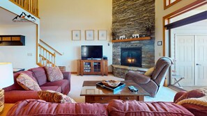 A living room with a stone fireplace, a television, and a comfortable seating area. - Reserve 32B • Family-Friendly Mountain Stay (Sugar Mountain)