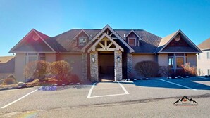 A two-story house with a stone entrance, a garage, and a driveway with parking spaces. - Reserve 32B • Family-Friendly Mountain Stay (Sugar Mountain)