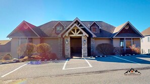 A two-story house with a stone entrance, a garage, and a driveway with parking spaces. - Reserve 32B • Family-Friendly Mountain Stay (Sugar Mountain)