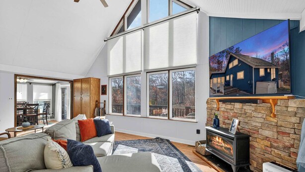 A spacious living room with a fireplace, large windows, and a cozy seating area. - Dog-Friendly Chalet in The Woods Resort w/ Fire Pit (Hedgesville)