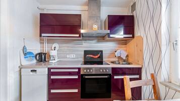 A compact kitchen with a built-in oven, a coffee maker, and a microwave.