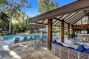 An outdoor pool area with lounge chairs, umbrellas, and a bar. - Sensational Swim Out—Resort Living by the Sea (Palm Cove)