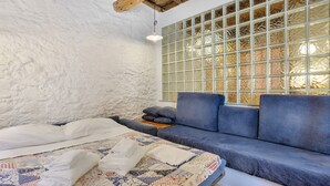 Una stanza con un letto, un divano blu e un'ampia finestra vista panoramica.