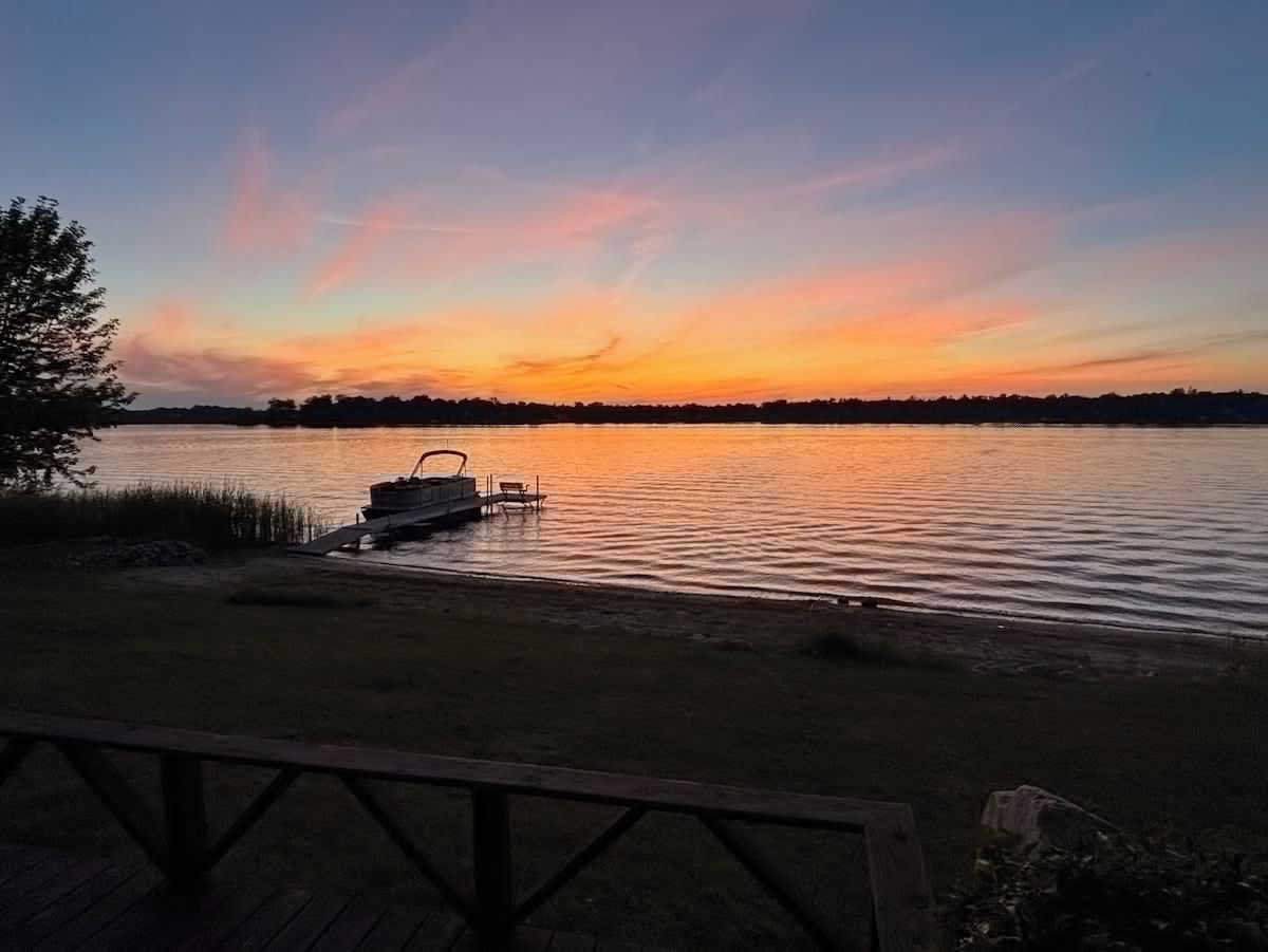 A lakeside view with a dock and a wooden deck.