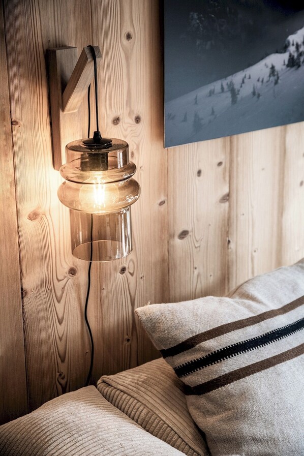 A wooden wall with a hanging light fixture and a framed picture of a snowy mountain. - Snowdust – Warm & Welcoming Stay in Megève (Megeve)