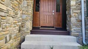 A stone building with a wooden double door and concrete steps leading to a dark entrance. - Snowcreek Resort Vacation Rental 1543 (Mammoth Lakes)