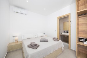 A modern bedroom with a bed, bedside lamp, and a wooden wardrobe. - Villa Salty Sun 5 - Two Bedroom Villa, Sleeps 4 (Kremasti)