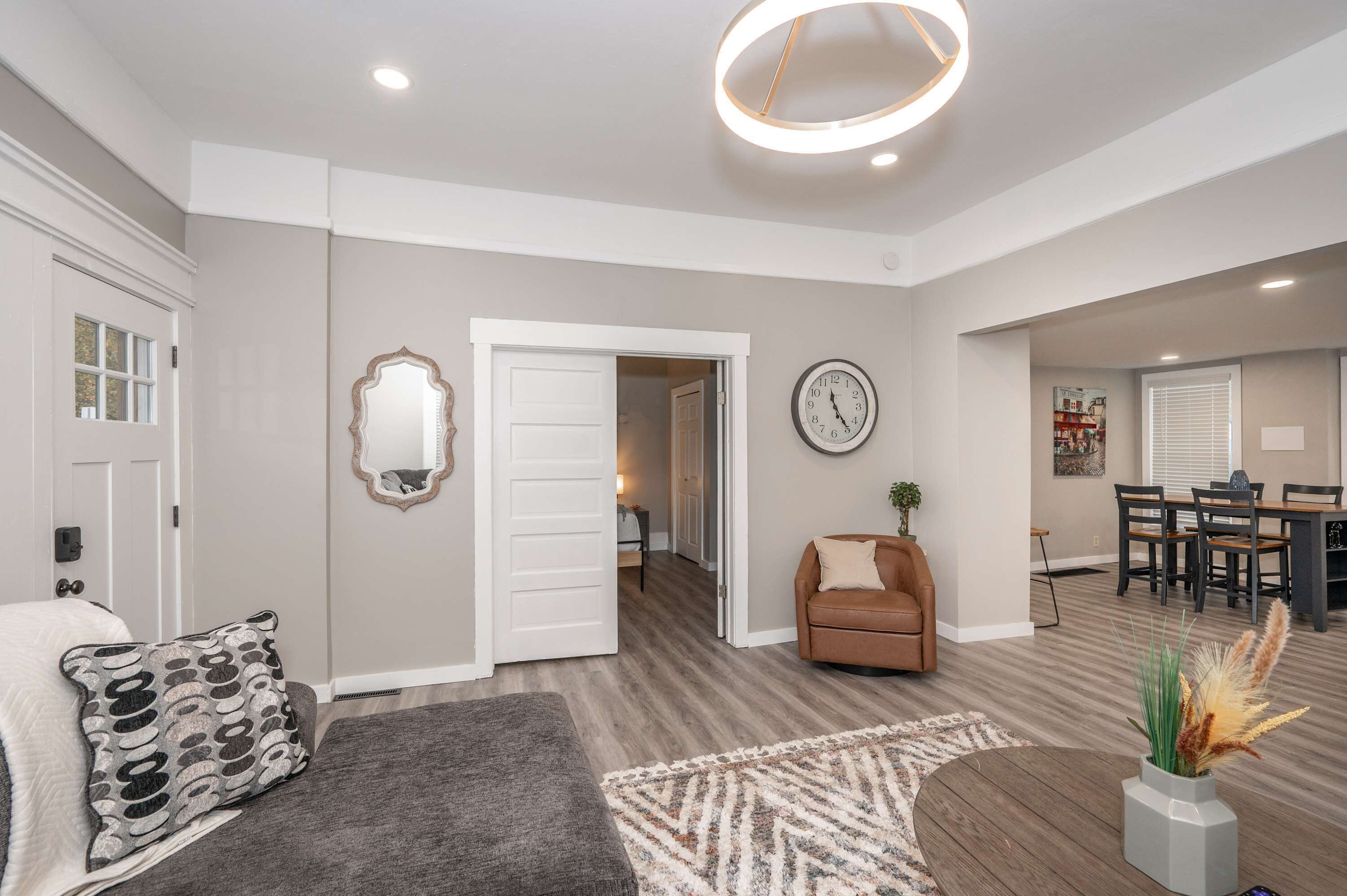 A spacious living area with a sofa, a coffee table, and a decorative mirror.