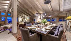 A spacious dining area with a long table set for a meal, surrounded by comfortable seating. - MONTCLAIR HOME - Four Bedroom Apartment, Sleeps 8 (Verbier)