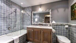 A modern bathroom with a glass-enclosed shower, a wooden vanity with a marble countertop, and a large mirror above the sink. - MONTCLAIR HOME - Four Bedroom Apartment, Sleeps 8 (Verbier)