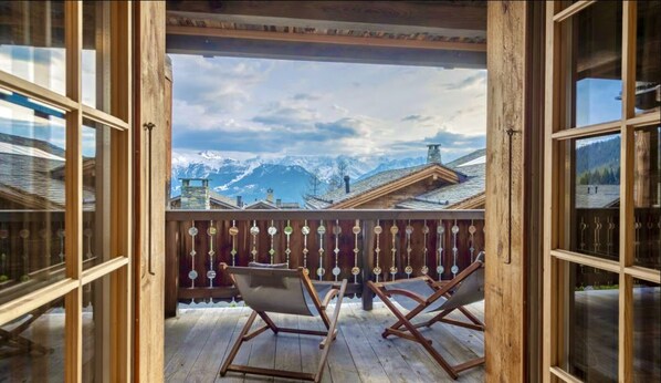 A wooden balcony with two lounge chairs facing a mountain view. - MONTCLAIR HOME - Four Bedroom Apartment, Sleeps 8 (Verbier)