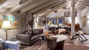 A spacious living area with a leather sofa, a dining table, and a chandelier. - MONTCLAIR HOME - Four Bedroom Apartment, Sleeps 8 (Verbier)