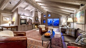 A spacious living area with a fireplace, a television, and a view of the outdoors. - MONTCLAIR HOME - Four Bedroom Apartment, Sleeps 8 (Verbier)