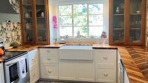 A kitchen with a large window, wooden cabinets, a built-in oven, and a patterned tile floor. - Massey's in the Park (Vicksburg)