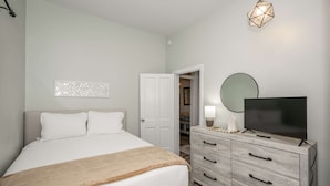 A bedroom with a bed, a dresser, a television, and a closet. - Harrison 3BR Walk Downtown Sleeps 6 (Harrison)