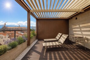 A wooden deck with a pergola, a table, and two lounge chairs. - Boutique Hotel OPERA (Rijeka)