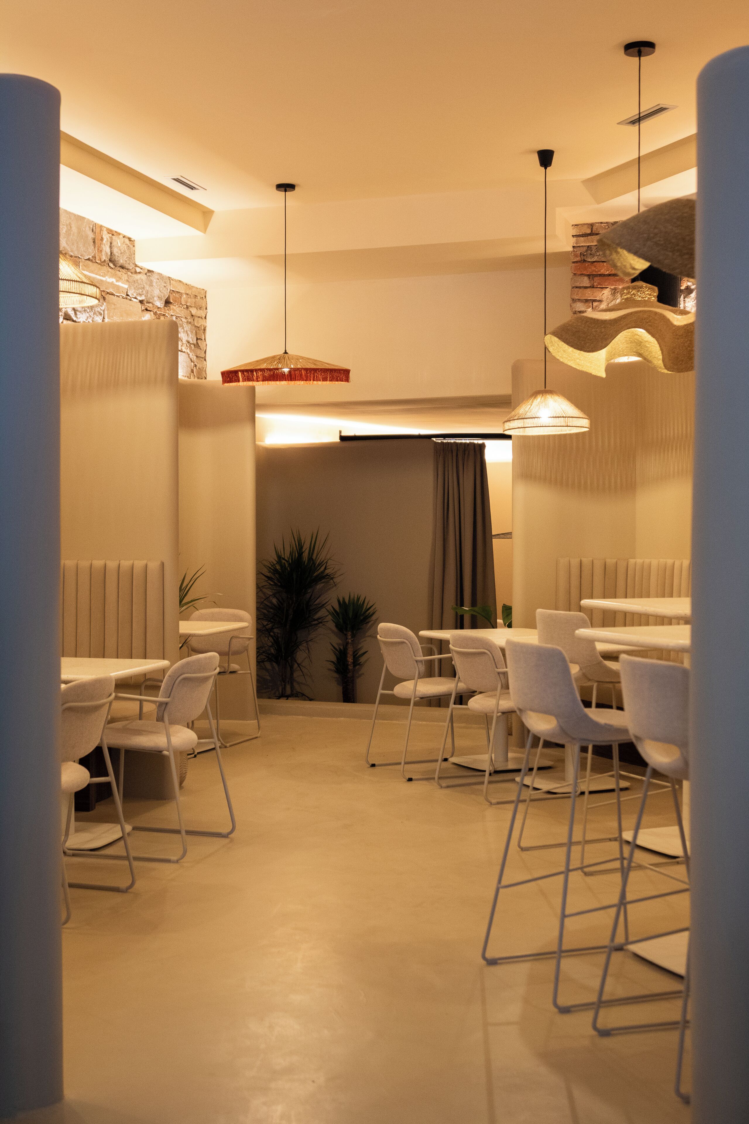 Een moderne eetruimte met witte meubels en hanglampen.