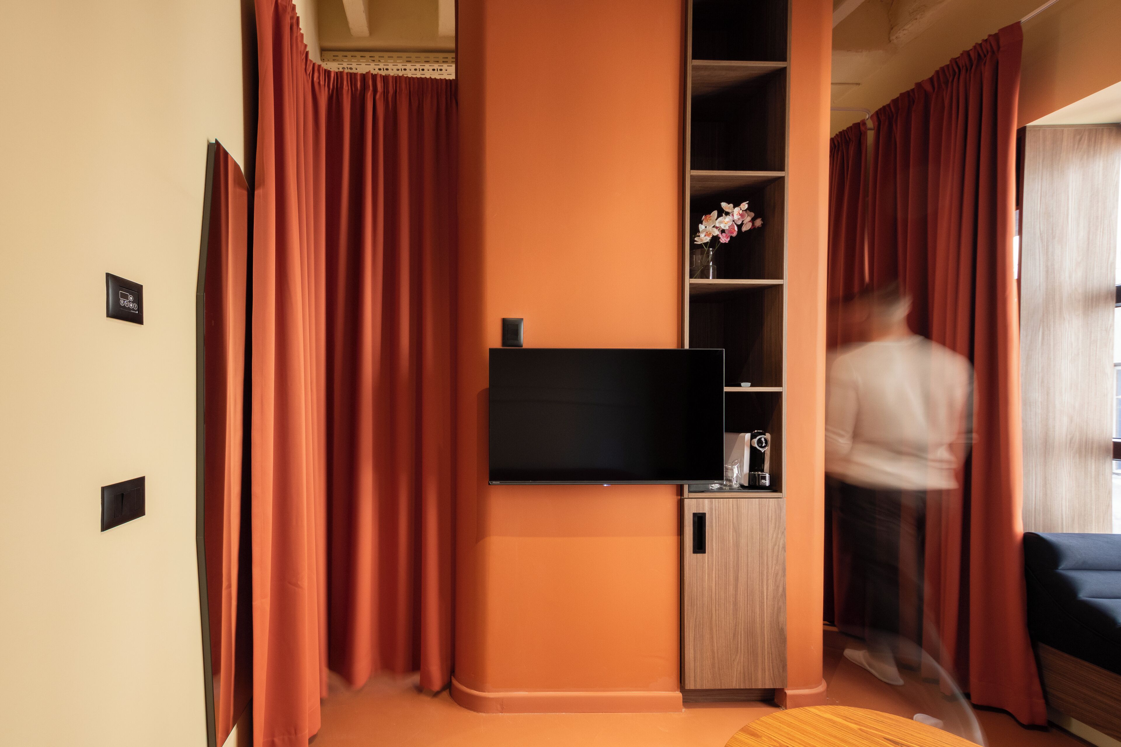 Una sala de estar moderna con una televisión de pantalla plana, armarios de madera y un sofá.