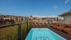 A rooftop pool with lounge chairs and a view of the cityscape. - Boutique Hotel OPERA (Rijeka)