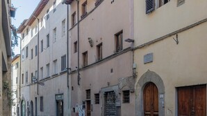 Eine schmale Straße mit Gebäuden an beiden Seiten, mit rundbogigen Hauseingängen und einem Fahrrad, das am Gehweg steht.