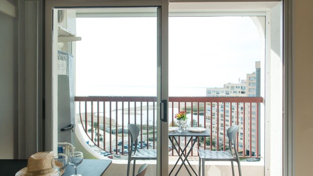 A balcony with a table set for two, a chair, and a decorative item. - WELCS STUDIO 294 EMP with sea view (Empuriabrava)