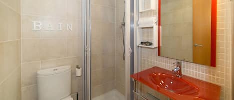 Un baño con inodoro, ducha y lavamanos.