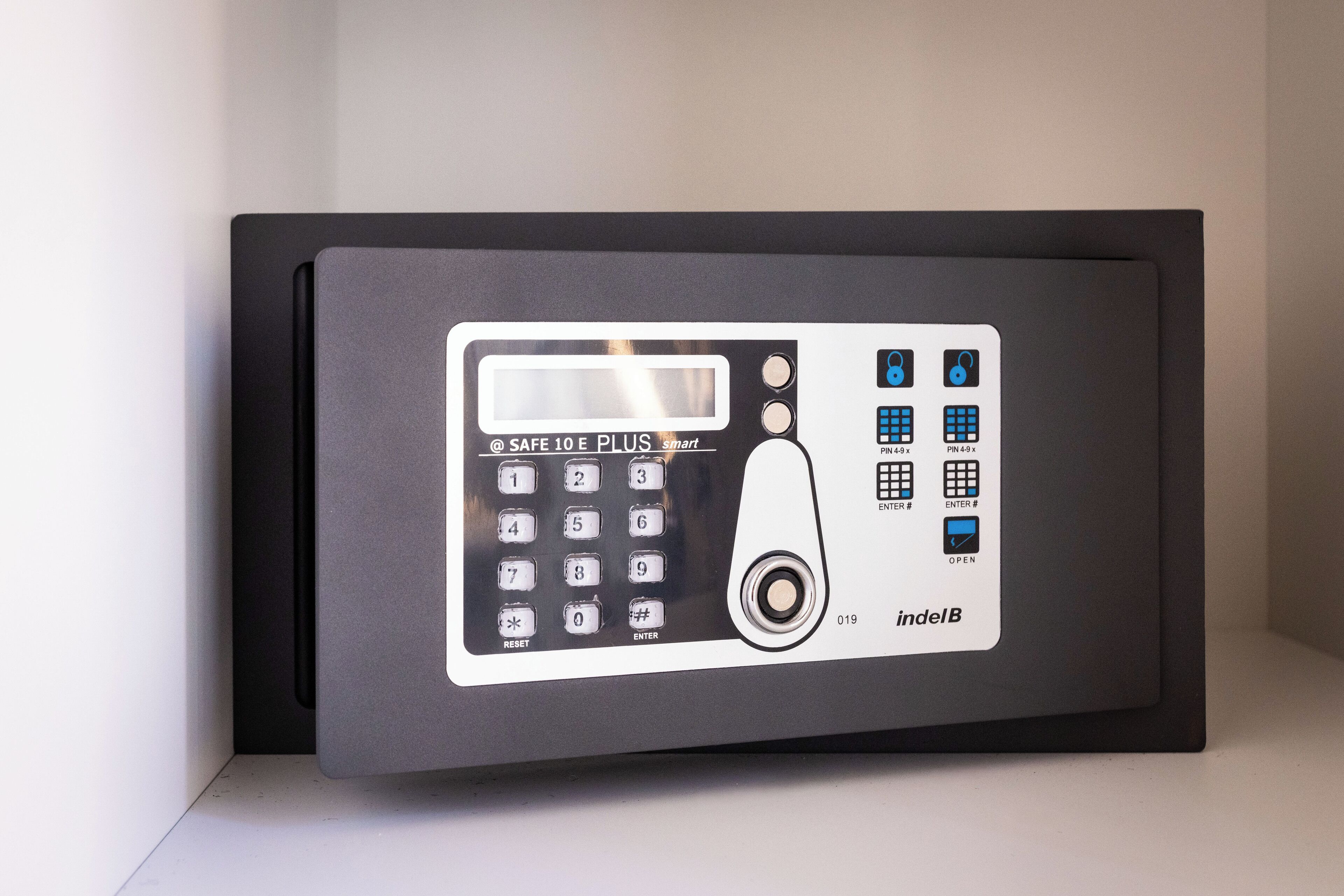 Un panel de control de seguridad moderno, de color negro, con pantalla digital, varios métodos de acceso y un botón de restablecimiento.