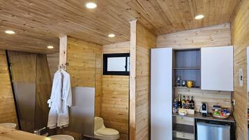 Une petite salle de bain avec un plafond en bois, un lavabo blanc et des toilettes.