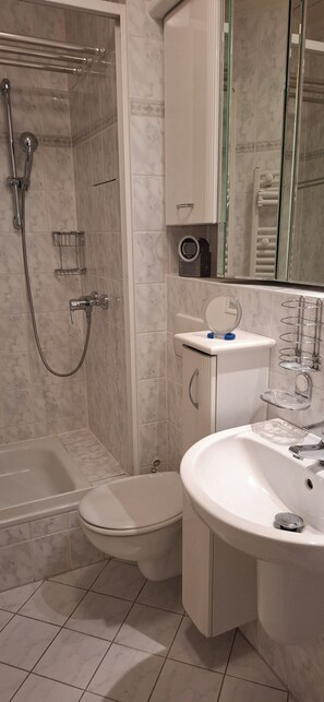 Een douche, handdoeken, zeep, toiletpapier