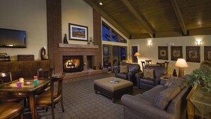 Una sala de estar acogedora con chimenea, asientos cómodos y televisor.