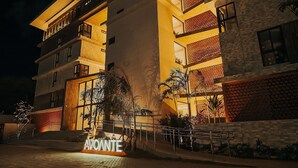 Ein mehrstöckiges Hotel mit einem markanten Eingang und einem Schild mit der Aufschrift 'AVONTE'.