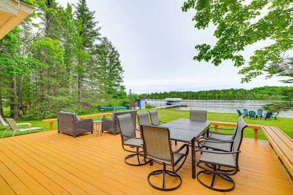 Une terrasse dotée de mobilier d’extérieur, donnant sur un lac.