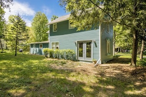 A two-story house with a front yard, a small porch, and a garage.