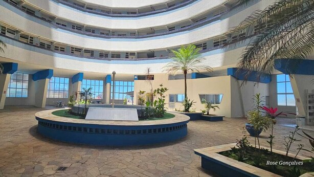 A spacious atrium with a central fountain, multiple levels, and potted plants. - 2-BEDROOM APARTMENT - FULLY FURNISHED - BEACHFRONT - PET FRIENDLY - DREAM BEACH (Itanhaém)