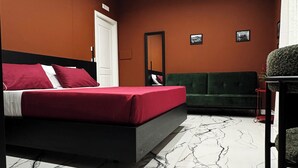 Ein Schlafzimmer mit einem Bett, einem grünen Sofa und einem Marmorboden.