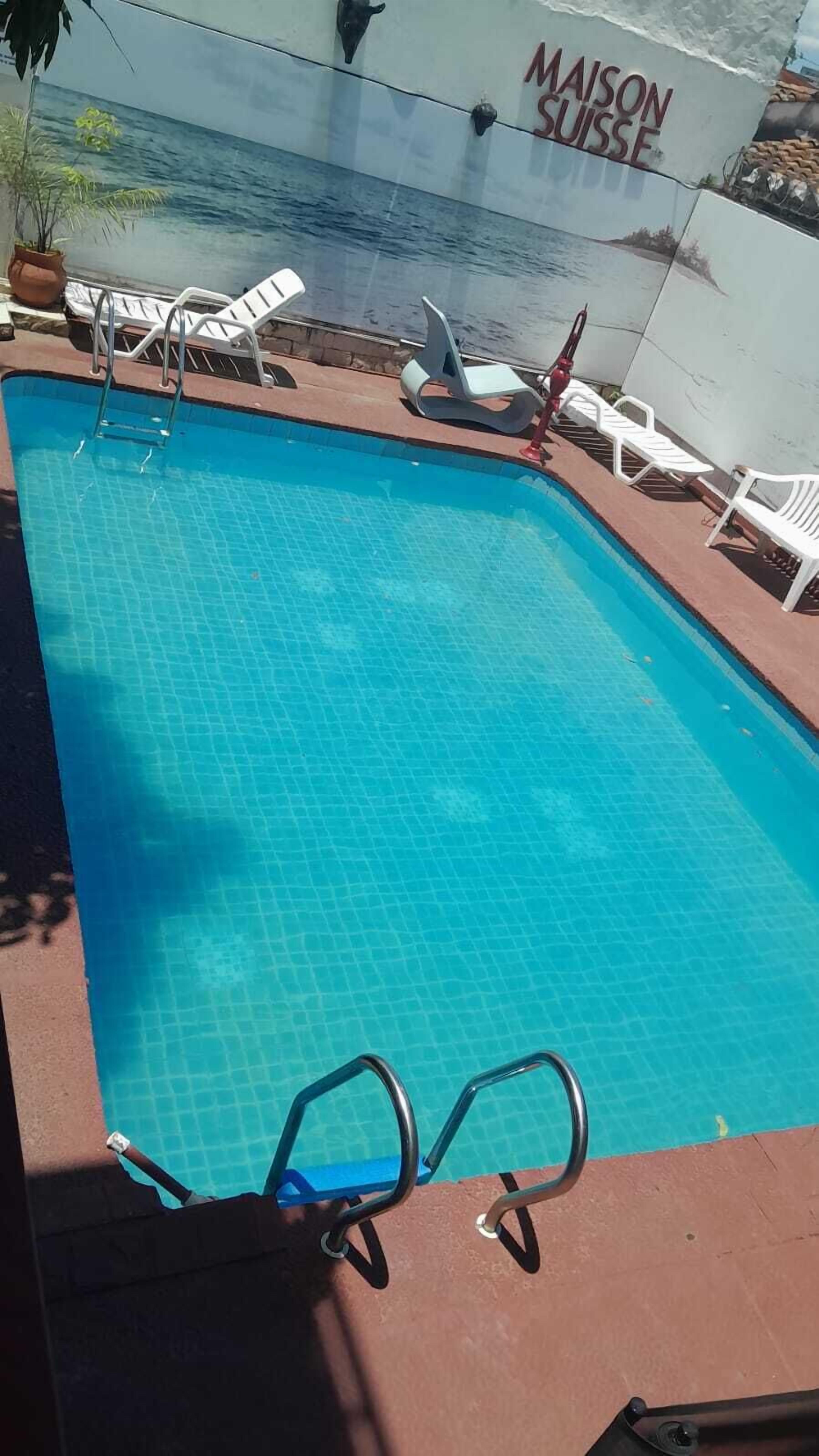 Una piscina con sillas de descanso y un puesto de socorristas.