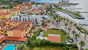 Une ville côtière dotée d’un port de plaisance, de bâtiments aux couleurs vives et d’une piscine.