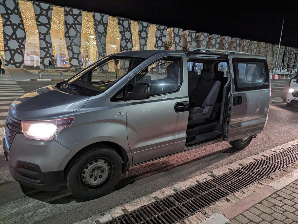 A silver van parked on a street at night.
